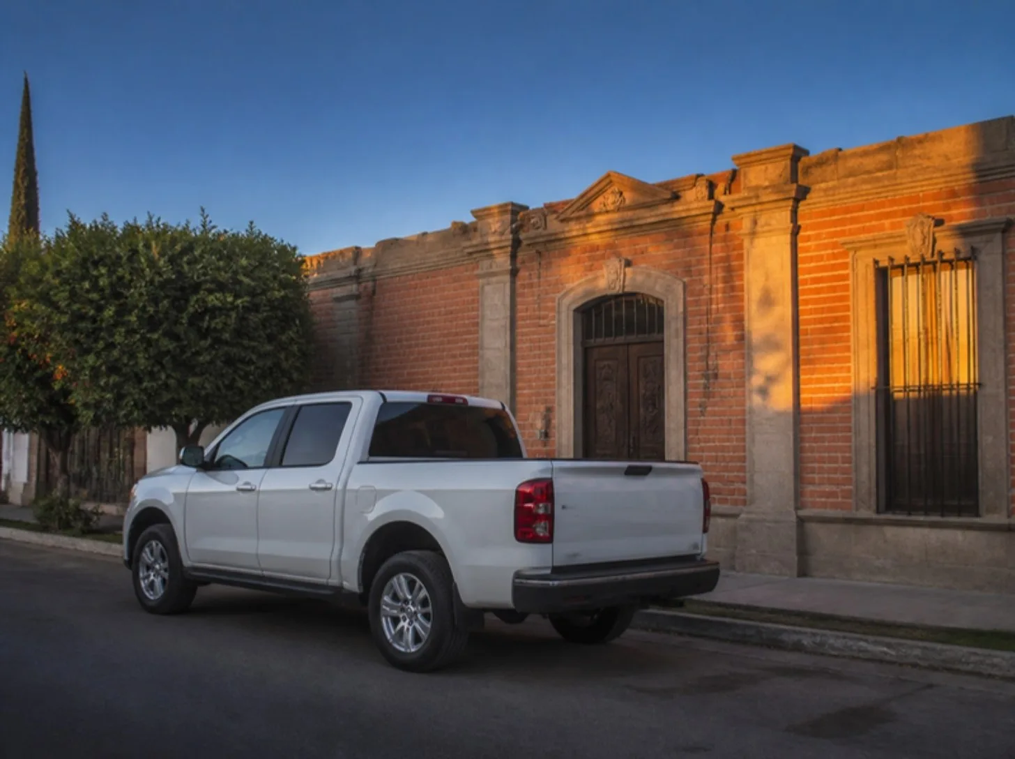 Camioneta frente a casa de ladrillo
